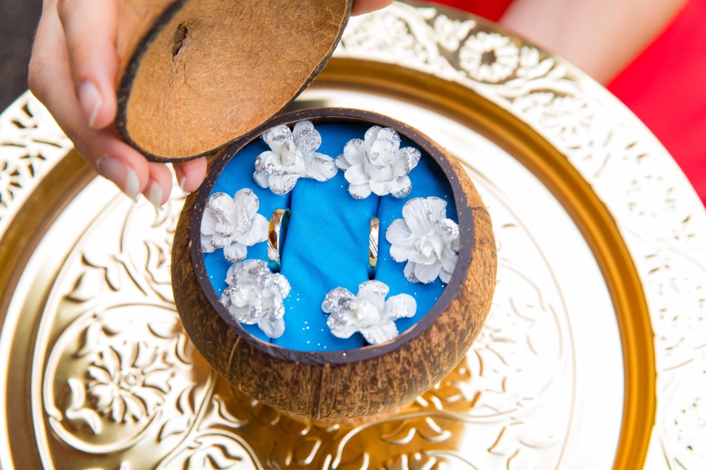 Les deux Alliances dans leur écrin, une noix de coco déposée sur un plateau doré, prêtent à aller vers les mariés.